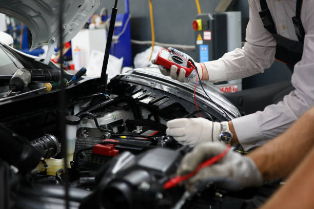 Two specialists of service for repairing wiring and computer diagnostics car solve problem engine malfunction. Serviceman collaborate education training concept. New technology studyng